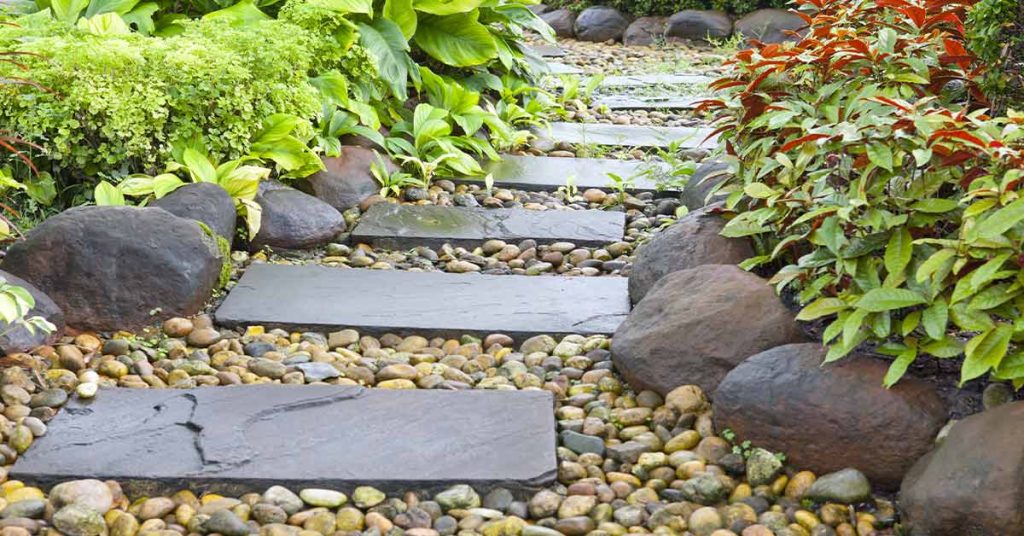 This is a picture of a flagstone path going through lush landscaping.