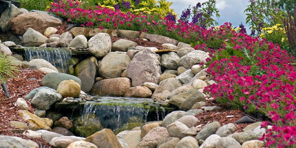 This is a picture of river rock being used in a landscape with flowers in spring near Atlanta, GA.