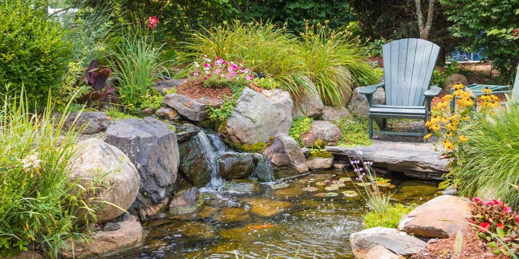 This is a picture using landscaping rock as a retaining wall between a garden and a water feature.